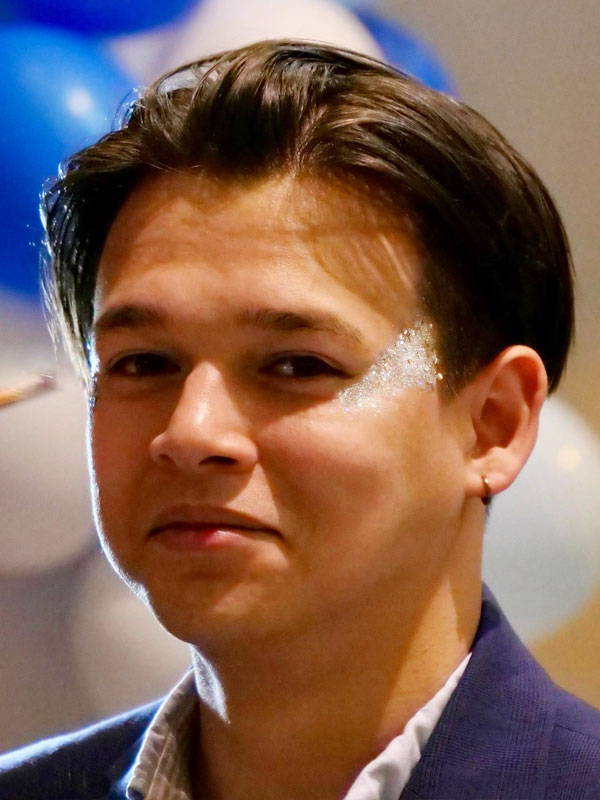 cheeky smile from a student with biodegarable glitter around his eye bu chers funky faces