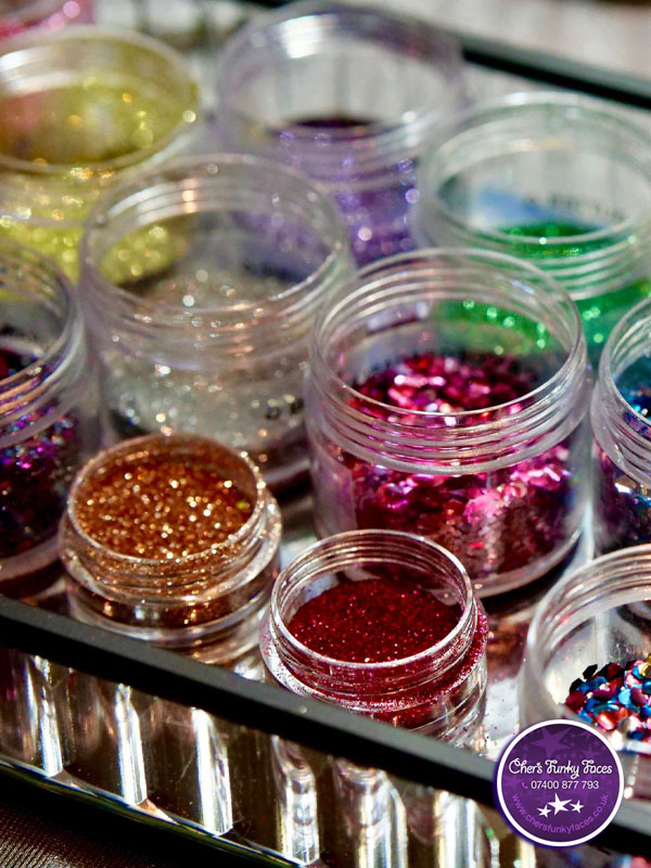 A selection of pots filled with biodegradable glitter in a rainbow of colours