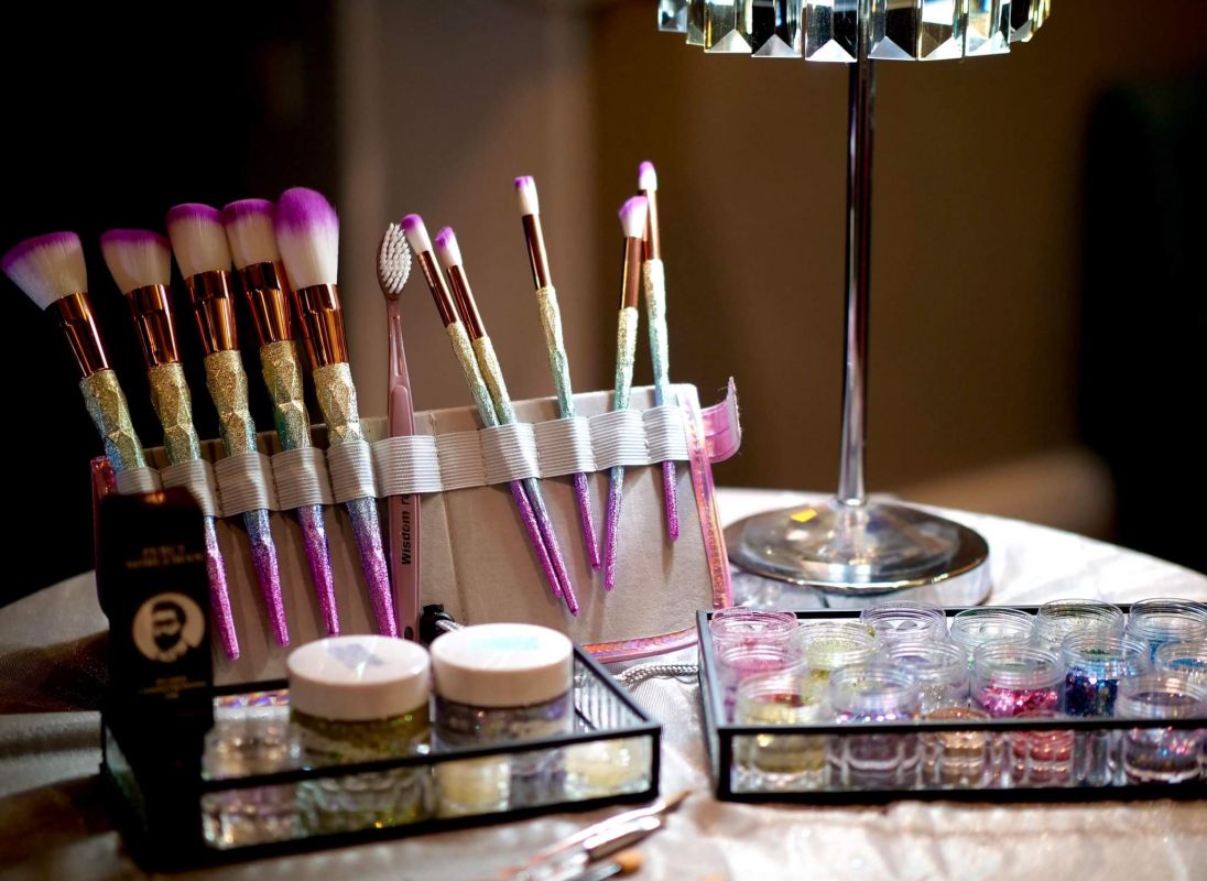 Brushes and glitter with light behind glitter bar