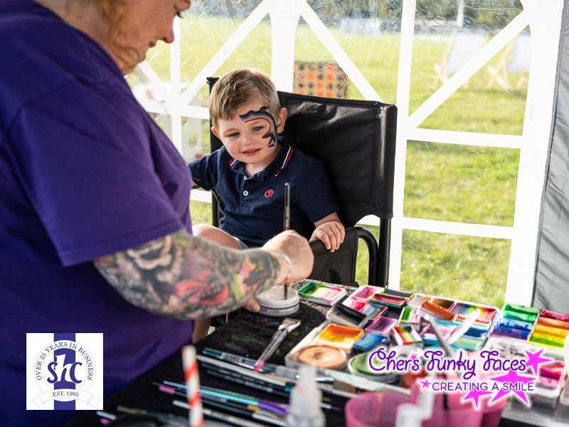Sophia creating face painted shark smiles at steve hoskin constructions families fun day chers funky faces