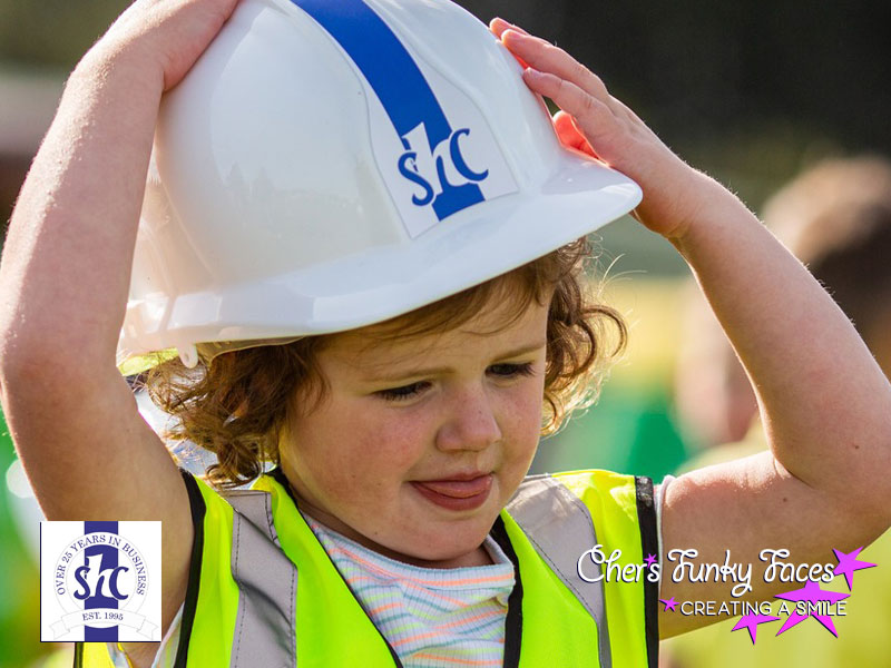 Young child wearing steve hosking construction hard hat at family fun day