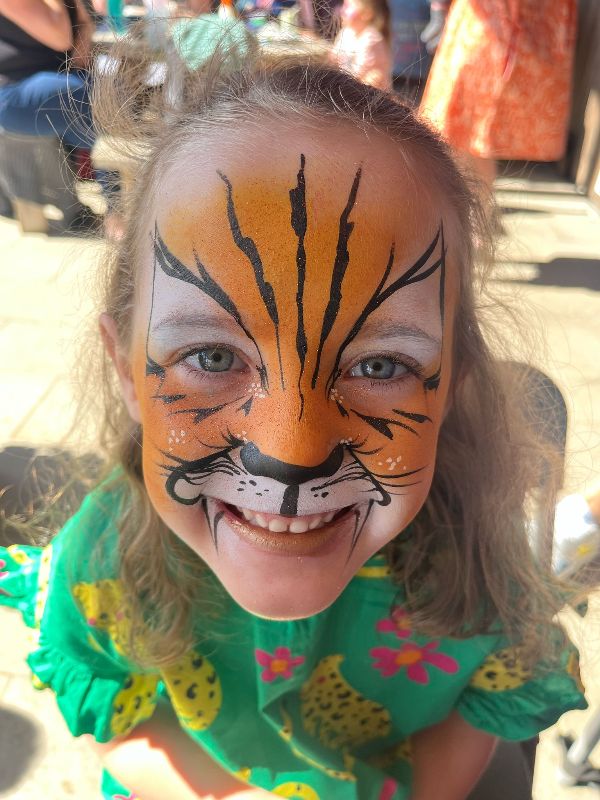 Orange and black tiger facepaint on little girl